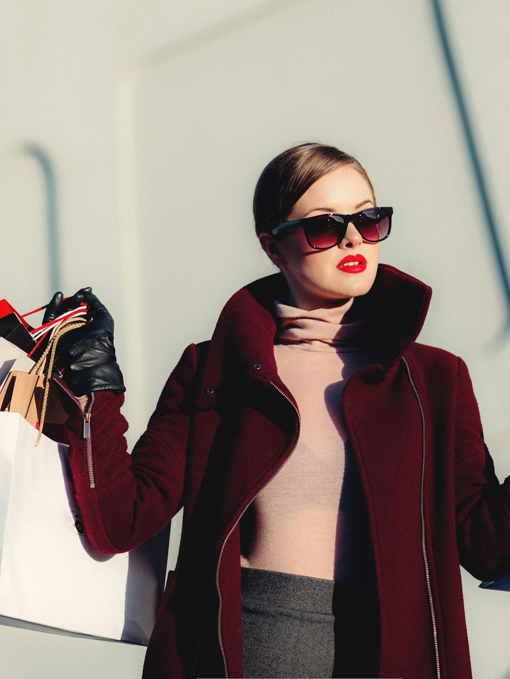 A belted wool coat and leather gloves, worn with sunglasses